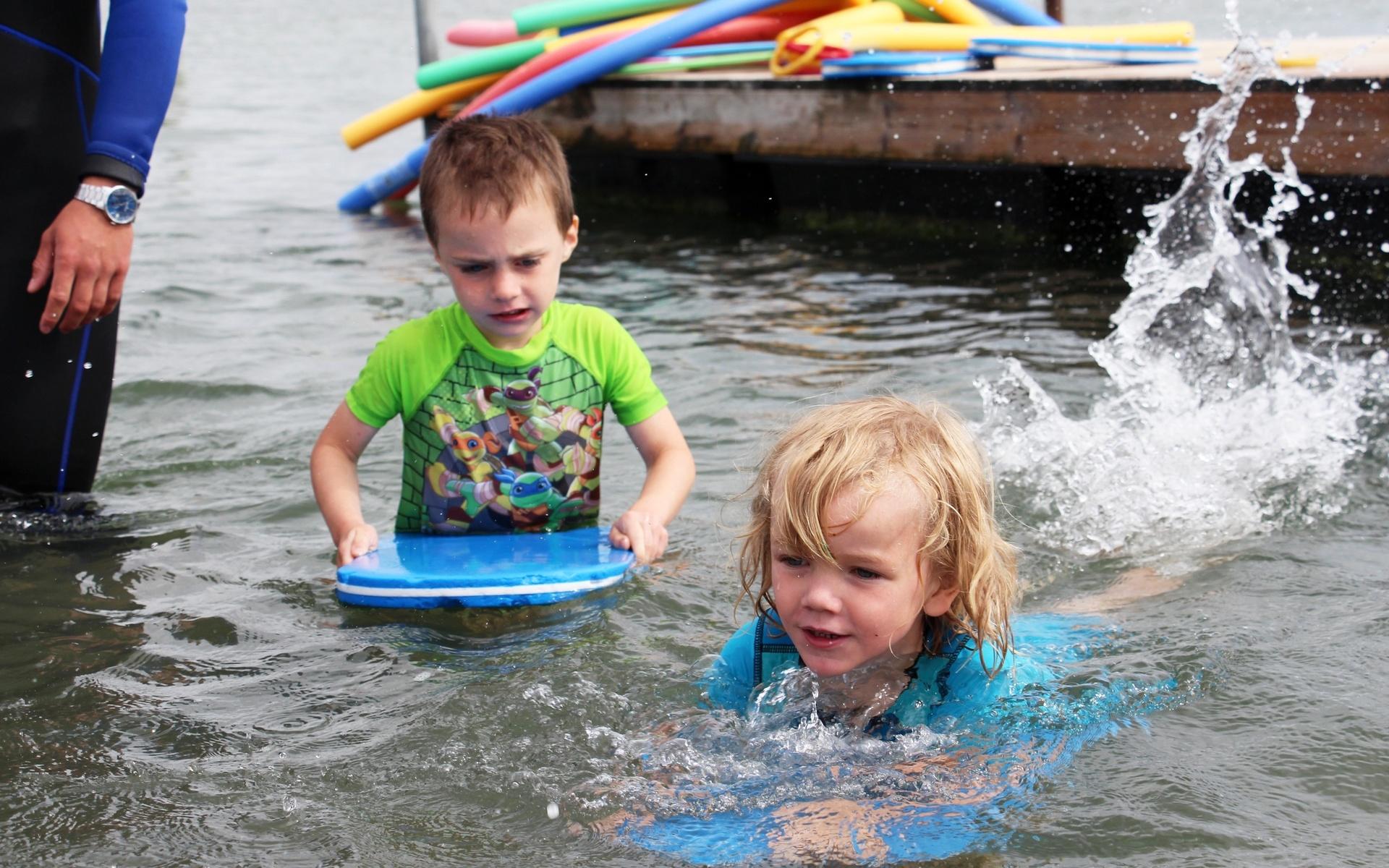Jonathan Reed, fem år och Axel Härsjö, fem år, simmar med flytplattorna.