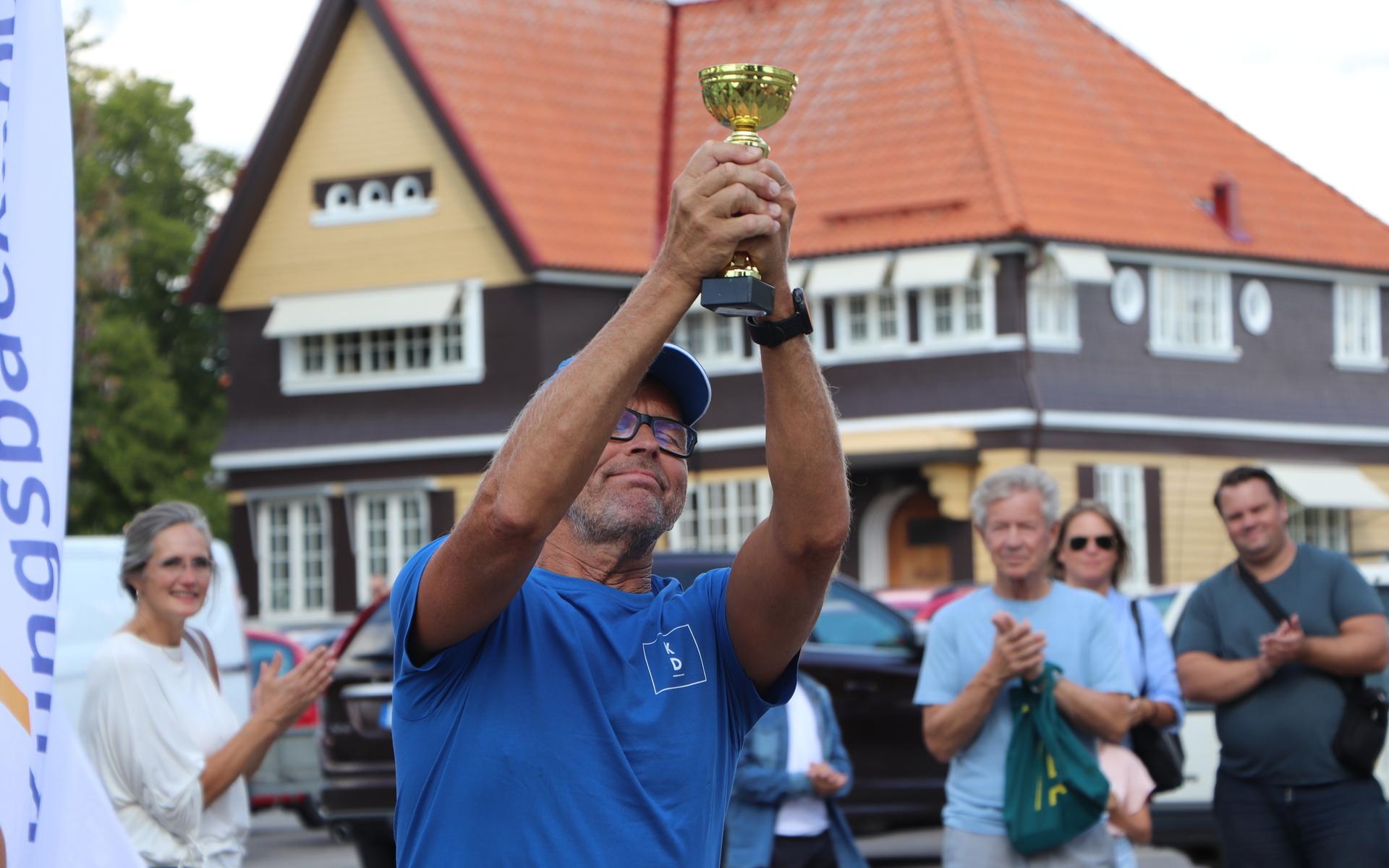 Vinnaren Mats Nyberg (KD) lyfter sin pokal med ett gott humör. 