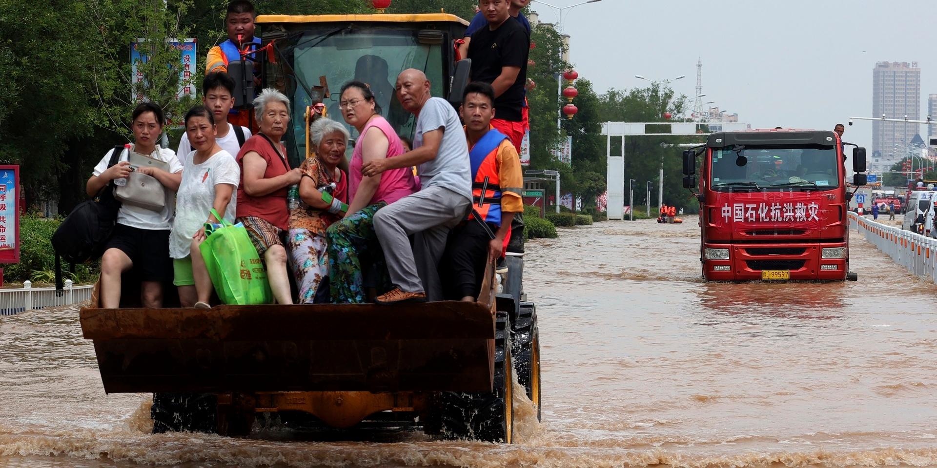 Människor räddas undan översvämningarna i Henan i Kina.